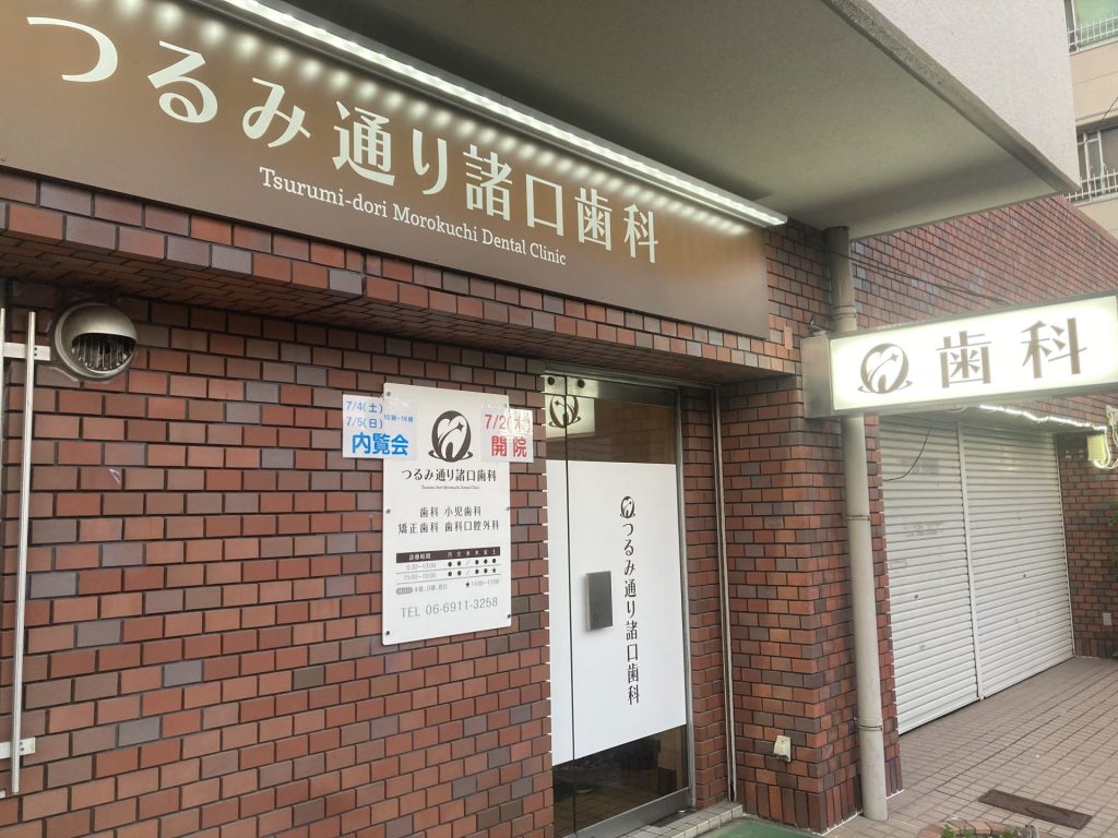 1階にある茶色のレンガの建物と茶色の看板、歯の中を星が昇っていくロゴが目印です。